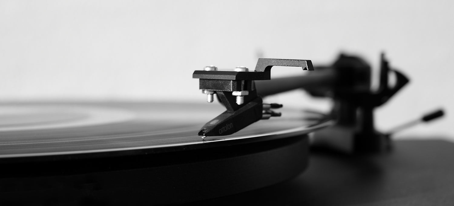 A record sits atop a record player, with its stylus in the record's groove.